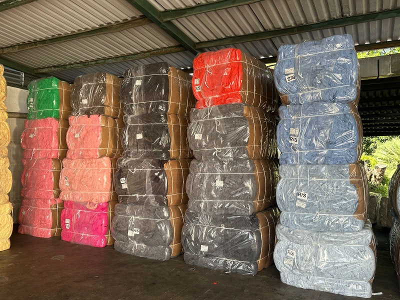 Baled cutter clips stacked by colour under a warehouse roof