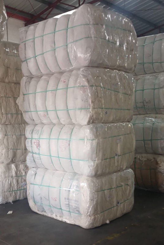 Strapped white cotton bales stacked four high
